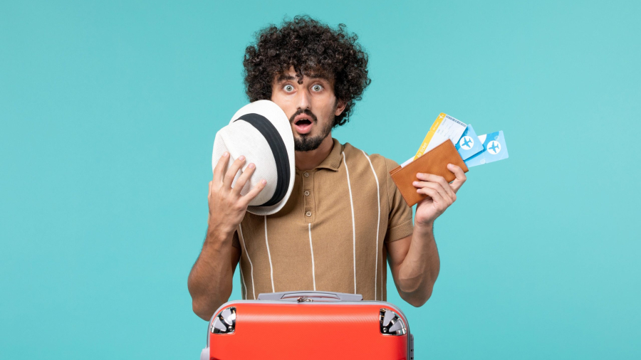 man-vacation-holding-tickets-light-blue-scaled.jpg