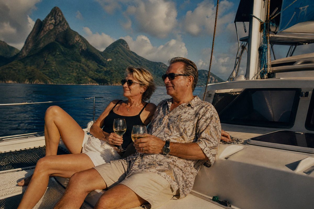 Couple relaxing with a glass of wine on the deck of a sailing catamaran