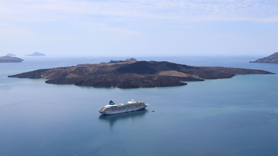 Cunard cruise ship sailing near a Greek island coastline